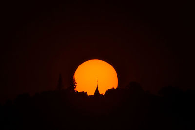 Silhouette cross against sky during sunset