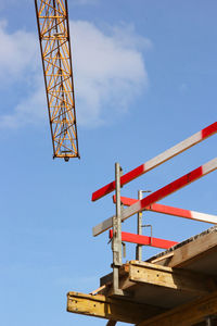 Low angle view of crane against blue sky