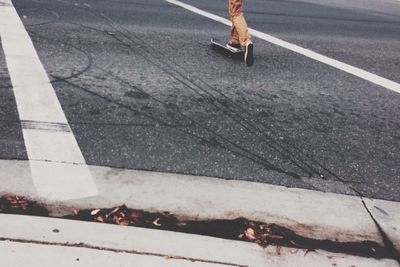 Low section of person skateboarding on street