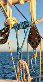 Close-up of rope tied to bollard against sky