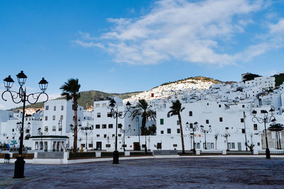 Buildings in town against cloudy sky