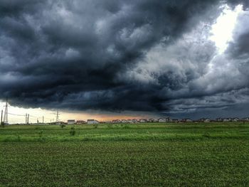 Scenic view of field against dramatic sky