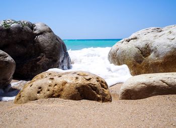 Rocks on beach against clear sky