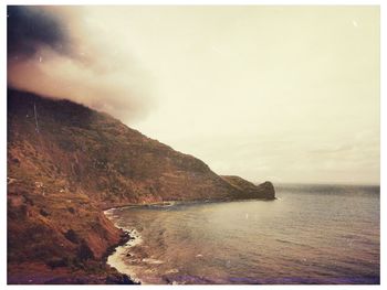 Scenic view of sea and mountains against sky