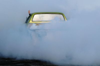 Car releasing smoke on road