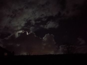 Low angle view of silhouette lightning against sky at night