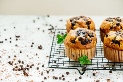 Close-up of muffins with chocolate chips on cooling rack at table