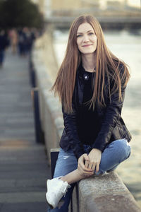 Portrait of young woman sitting outdoors