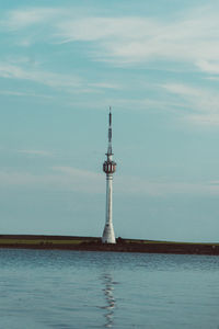 Lighthouse by sea against sky