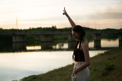 Full length of woman standing against sky during sunset