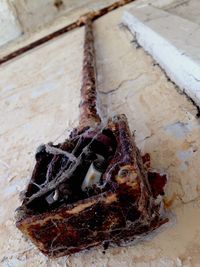 High angle view of abandoned rusty fuse box mounted on wall