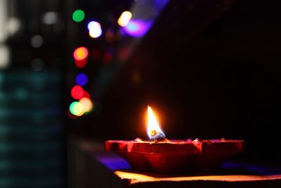 Close-up of lit diya on table