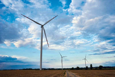 Low angle view of windmill on field against sky