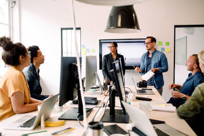 Male and female entrepreneurs giving presentation to coworkers in office