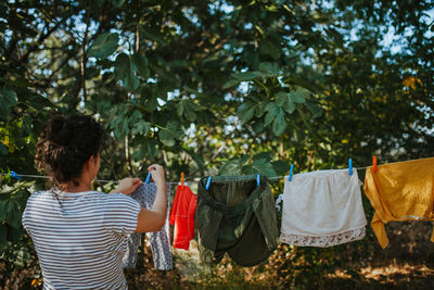 Rear view of woman drying clothes