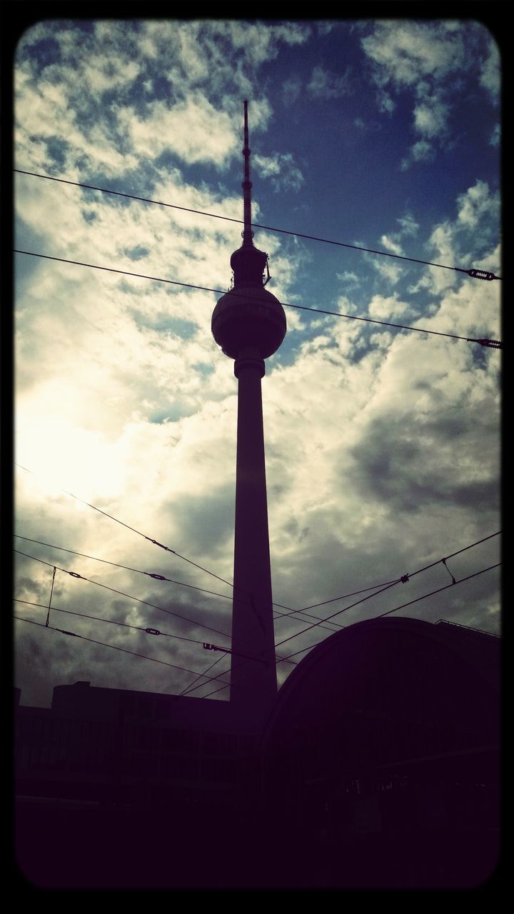 sky, communications tower, built structure, architecture, transfer print, tower, cloud - sky, tall - high, international landmark, low angle view, building exterior, auto post production filter, fernsehturm, spire, television tower, silhouette, famous place, cloudy, travel destinations, sunset