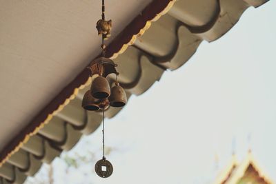 Low angle view of lighting equipment hanging against sky