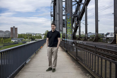 Portrait of young man standing on bridge