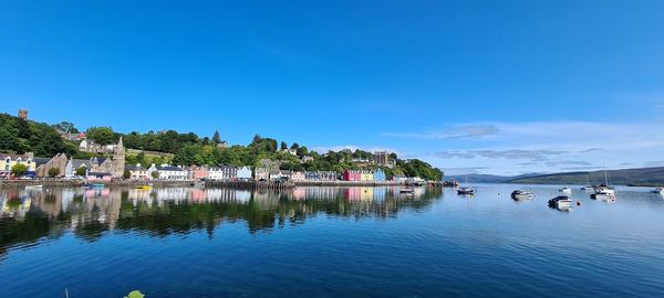 Scenic view of lake by trees against blue sky