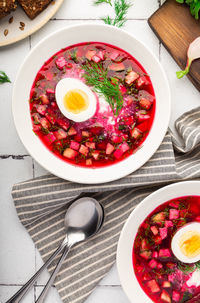 Summer cold beetroot soup with sour cream and egg on white tile background. russian cuisine. 