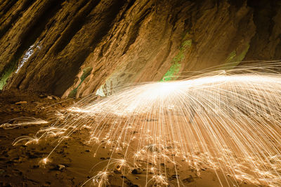 Low angle view of light trails on rock at night