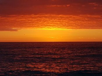 Scenic view of sea against orange sky