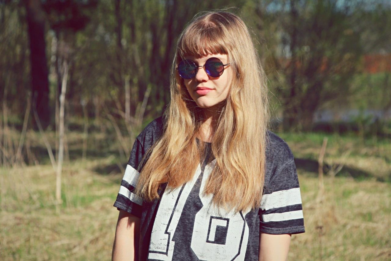 young adult, focus on foreground, lifestyles, young women, long hair, portrait, leisure activity, person, front view, casual clothing, looking at camera, standing, brown hair, waist up, sunglasses, holding, three quarter length