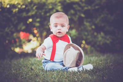 Portrait of cute boy sitting on grass