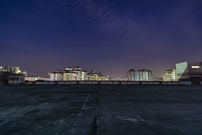 Illuminated buildings against sky at night