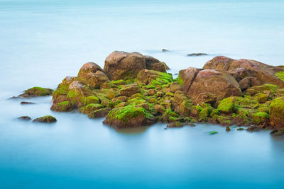 Rock formation in sea against sky