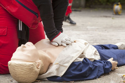 Midsection of paramedic performing cpr on mannequin