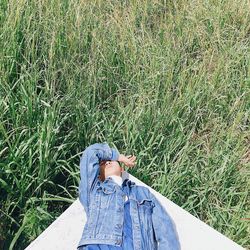 High angle view of young man lying on floor against grass