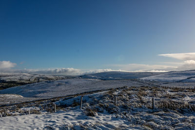 Scenic view of snow covered mountains against sky