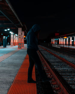 Rear view of woman standing on railroad station platform