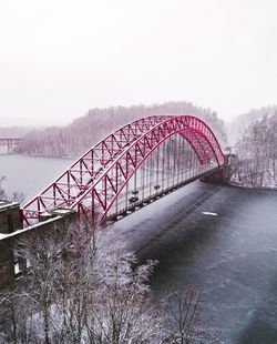 Arch bridge over river against clear sky