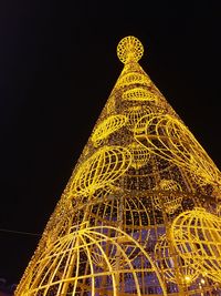 Low angle view of illuminated christmas lights against sky at night