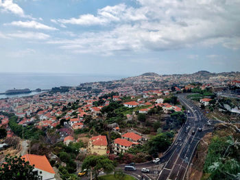 High angle view of buildings by sea against sky