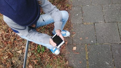 Low section of man standing on cobblestone