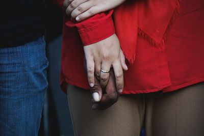 Midsection of couple holding hands