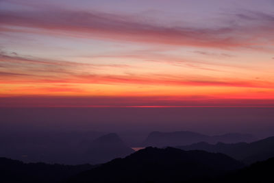 Scenic view of silhouette mountains against romantic sky at sunset