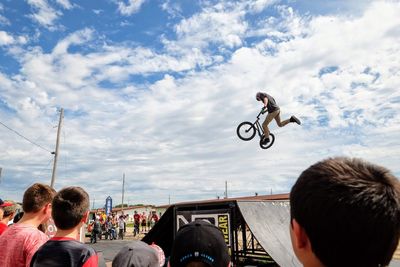 Rear view of people riding motorcycle against sky