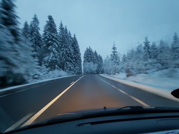 Road seen through car windshield during winter