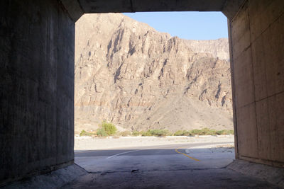 Road by mountains against sky