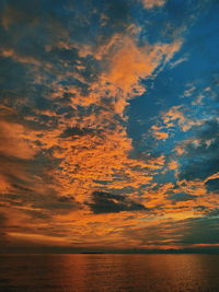 Scenic view of sea against dramatic sky during sunset