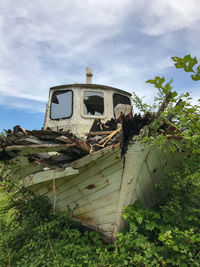 Abandoned truck on field against sky