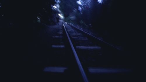 Low angle view of railroad tracks at night