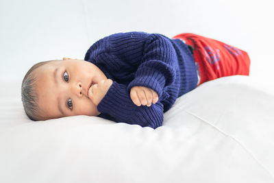 Infant boy lying cute facial expression with white background at indoor