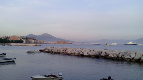 Boats moored in sea against sky