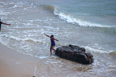 High angle view of boy jumping on beach