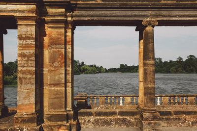 Architectural columns against river on sunny day at hever castle